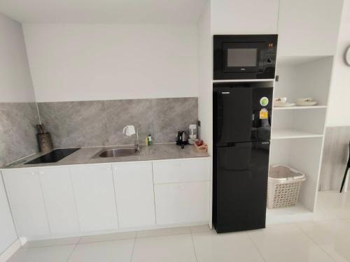 a kitchen with a black refrigerator and a sink at View Talay6 by Blue Ocean Suite in Pattaya Central