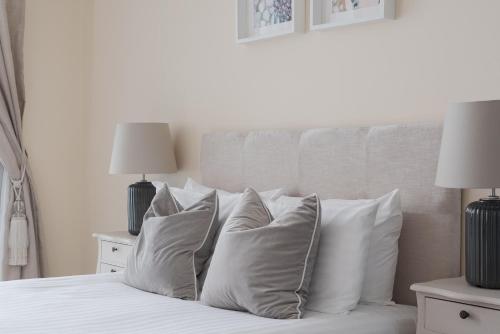 a white bed with white pillows and two lamps at City Stay Apartments - Hub in Milton Keynes
