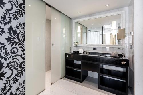 a bathroom with a sink and a mirror at Hotel Colón Gran Meliá - The Leading Hotels of the World in Seville