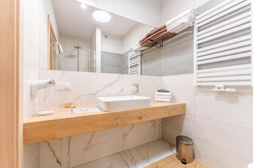 a bathroom with a sink and a mirror at Family Resort Sarbinowo in Sarbinowo