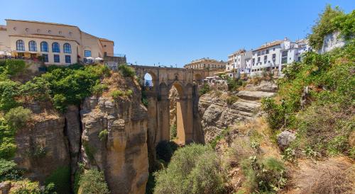 Un puente en una montaña con edificios al fondo. en The Gorge House, en Ronda