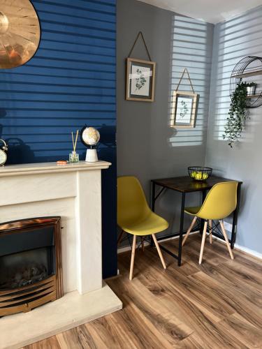 a living room with a fireplace and a table and chairs at 1 Bed Flat - Walton-on-Thames in Sunbury