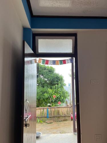 an open door with a view of a yard at The Blue House in Pelling