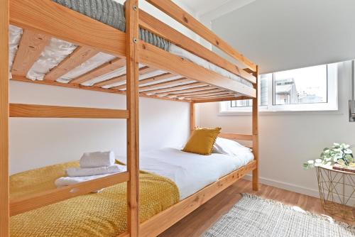 une chambre avec deux lits superposés avec des draps blancs dans l'établissement Apartamento Ponte D Luís, à Vila Nova de Gaia