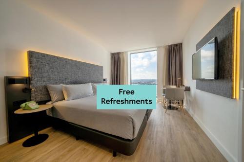 a bedroom with a bed with a sign that reads free refreshments at INNSiDE by Meliá Liverpool in Liverpool