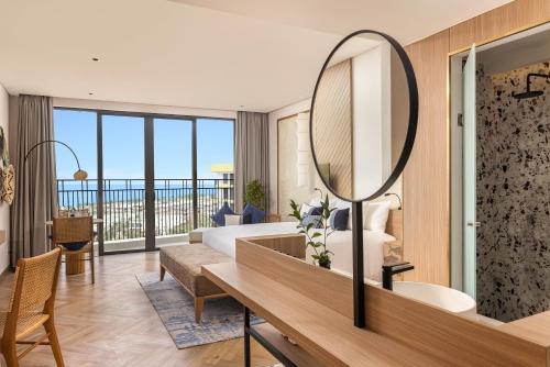 a bathroom with a large mirror and a living room at Wyndham Hoi An Royal Beachfront Resort & Villas in Hoi An
