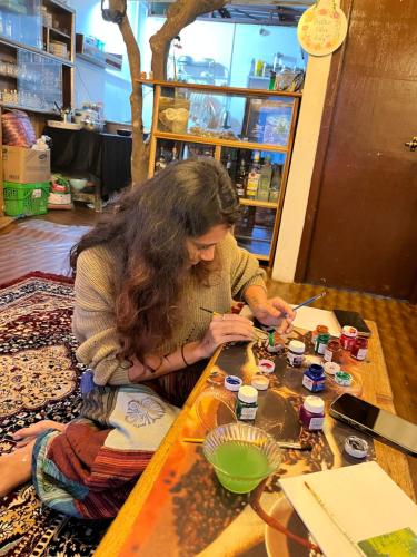a woman sitting at a table playing with beads at The Blue House in Pelling