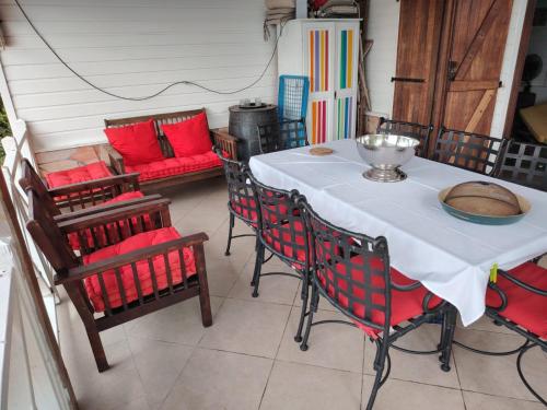 a table and chairs with a bowl on top of it at Charmant T3 climatisé Piscine privée in Le Diamant