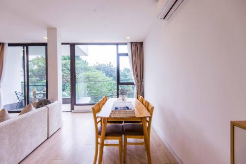 a dining room with a table and chairs and a couch at Paradise Apartment Quang Khanh in Hanoi