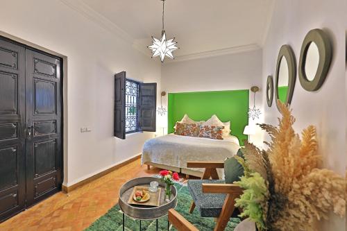 Un dormitorio con una cama y una pared verde. en Riad Dar Beldia and Spa, en Marrakech