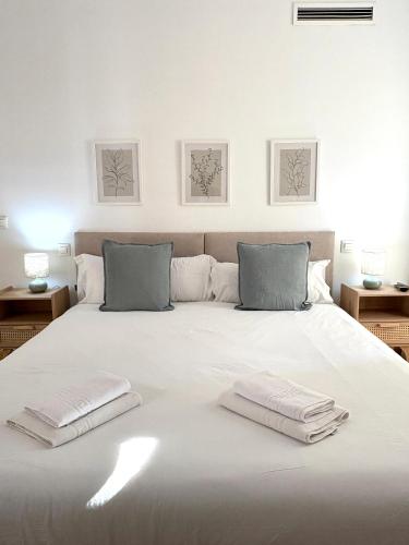 a white bed with two towels on top of it at The Zentral Suites & Apartments in Seville