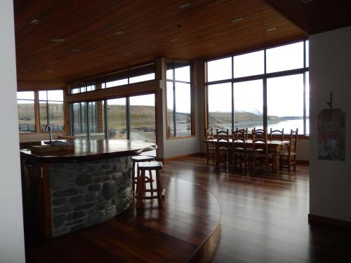 a living room with a table and chairs and windows at Isolation Bay in Lake Tekapo