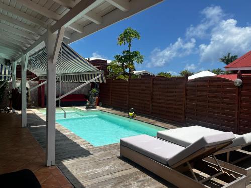 a swimming pool in a backyard with a wooden fence at Villa malaurelia in Saint-François