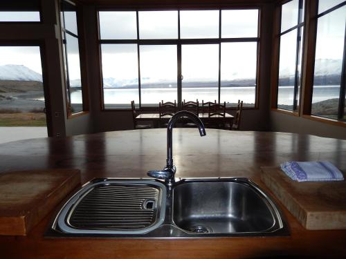 a kitchen sink with a view of the ocean at Isolation Bay in Lake Tekapo