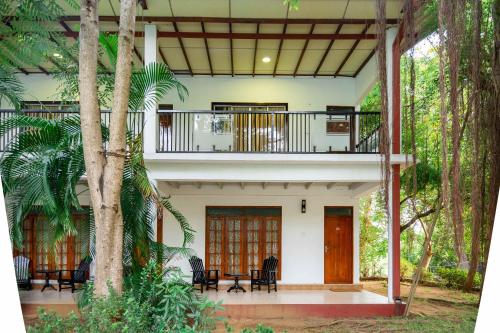 a house with a balcony in the middle of trees at JC's Village in Dambulla