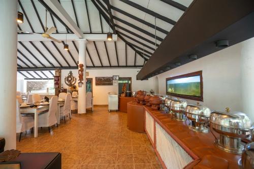 a restaurant with a bar with tables and chairs at JC's Village in Dambulla