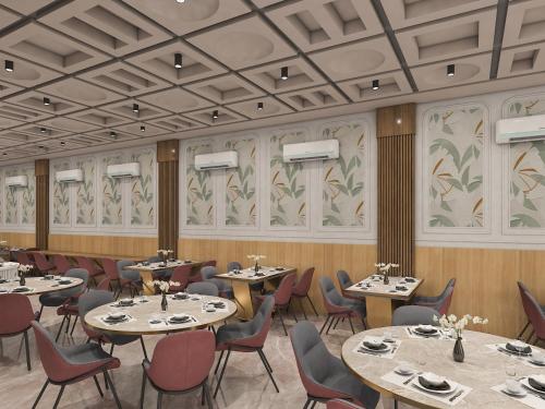 a restaurant with tables and chairs in a room at Radiant Sky Hotel in Kuchāman City