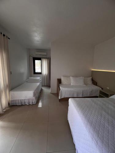 a bedroom with two beds and a window at Pousada Brisa do Mar in Torres