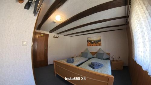 a bedroom with a bed in a room with a wooden ceiling at Gästehaus Eulenköpfchen in Neef