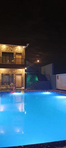 a large swimming pool at night with blue lights at Be delight corbett in Rāmnagar