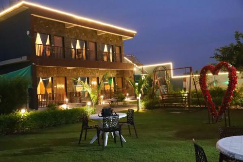 a house with a table and chairs in the yard at Be delight corbett in Rāmnagar