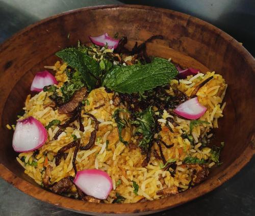 a wooden bowl filled with rice and vegetables at Be delight corbett in Rāmnagar