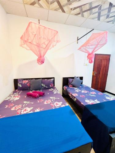 a room with two beds and two umbrellas at Marcelin Family Villa in Negombo