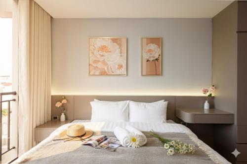 a bedroom with a bed with flowers on it at Nagomi Apartment in Hanoi