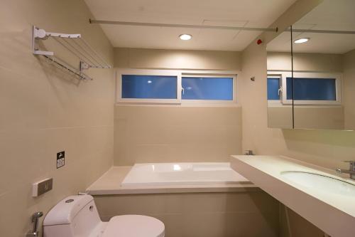 a bathroom with a tub and a toilet and a sink at Paradise Apartment Quang Khanh in Hanoi