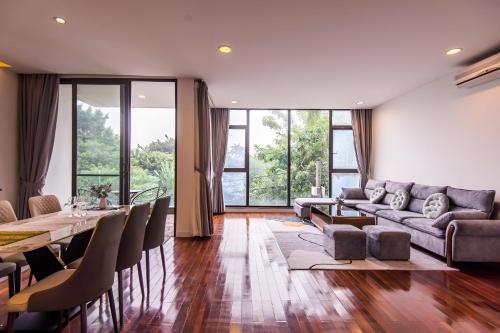 a living room with a couch and a table and chairs at Paradise Apartment Quang Khanh in Hanoi