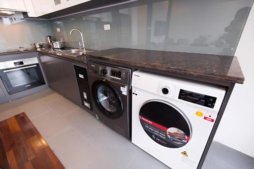 a kitchen with a washer and dryer under a counter at Paradise Apartment Quang Khanh in Hanoi