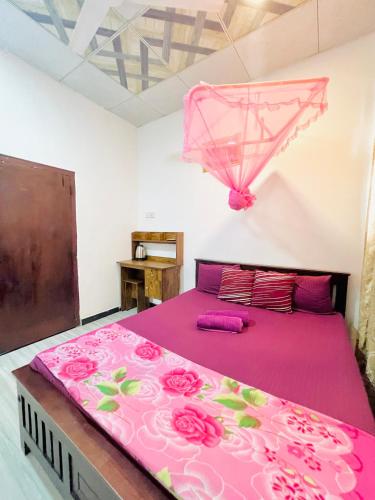 a pink bed with a pink umbrella in a room at Marcelin Family Villa in Negombo