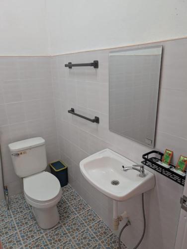 サワンナケートにあるMonkey Guest Houseの白いトイレと洗面台のあるバスルーム