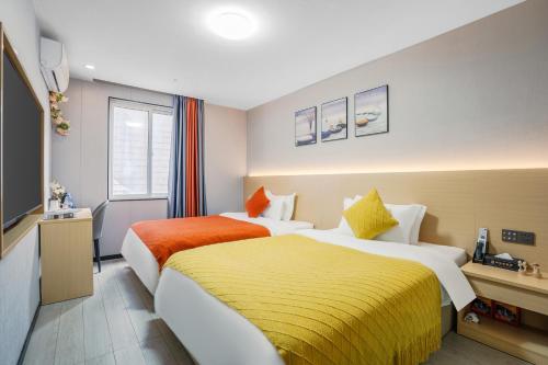 a hotel room with two beds and a television at L-Magic Design hotel in Guangzhou