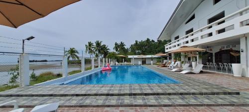 a swimming pool in front of a hotel at Chilly Beach Resort Palawan in Aborlan