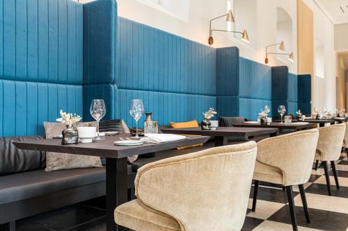 a row of tables in a restaurant with blue walls at MERICI Hotel Sittard in Sittard
