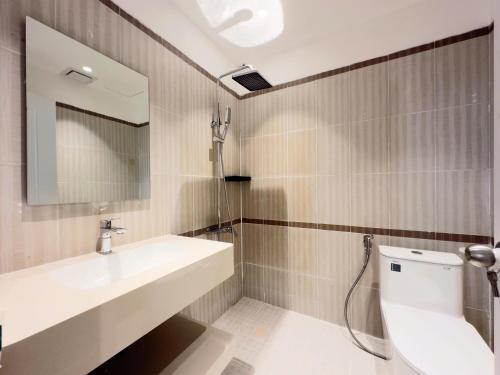 Un baño con lavabo, inodoro y espejo. en Wander Lane Hotel & Coliving, en Ho Chi Minh