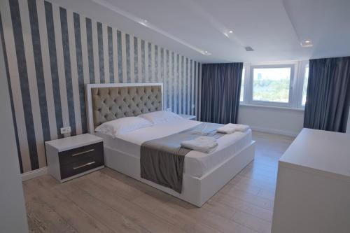a bedroom with a large bed and a window at 3D Hotel in Tirana