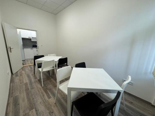 a room with white tables and chairs and a door at Leháro in Litoměřice