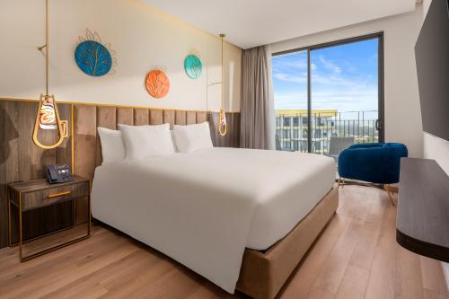 a bedroom with a large bed and a large window at Wyndham Hoi An Royal Beachfront Resort & Villas in Hoi An