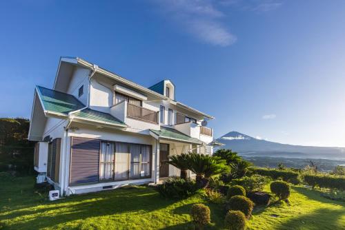 a house on a hill with mountains in the background at Fuji別邸 in Fujinomiya