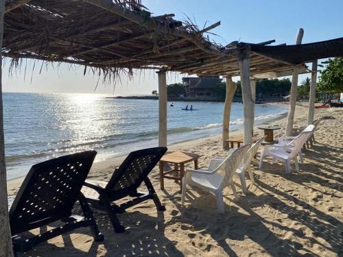 a group of chairs and a table on a beach at Sauka Loft Hostel in Rincón
