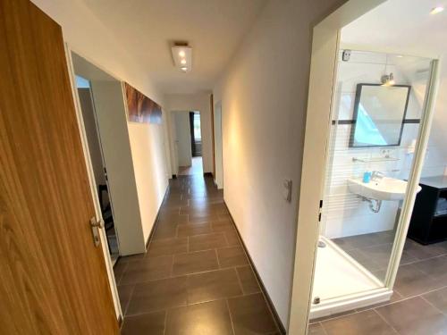 a hallway with a bathroom with a sink and a mirror at Tanne 16 - Bike & Familienurlaub in Braunlage in Braunlage