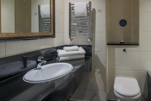 a bathroom with a sink and a toilet and mirror at Gloucester Robinswood Hotel, BW Signature Collection in Gloucester