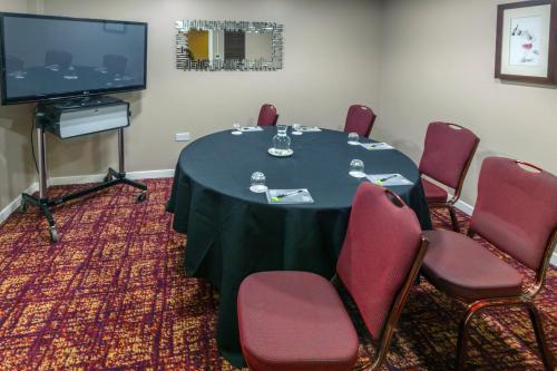 a conference room with a table and chairs and a television at Gloucester Robinswood Hotel, BW Signature Collection in Gloucester