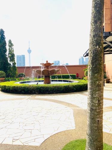 a fountain in the middle of a courtyard at My Service Suites Times Square KL in Kuala Lumpur