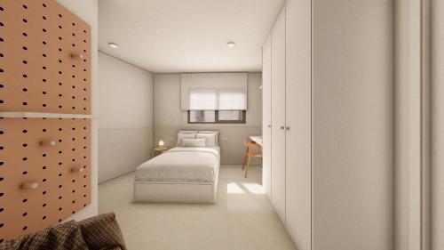 a white bedroom with a bed and a desk at CAN MATT Coliving and Residence in Tarragona