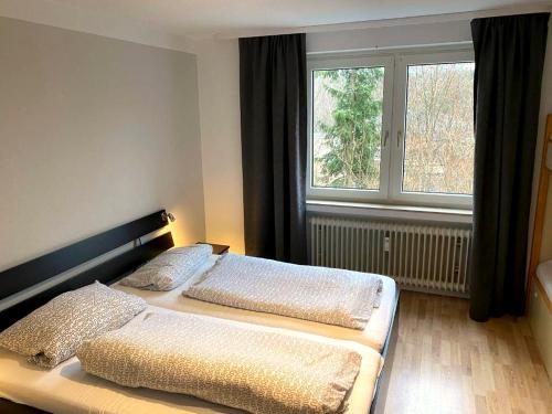 a bedroom with two beds in front of a window at Tanne 16 - Bike & Familienurlaub in Braunlage in Braunlage