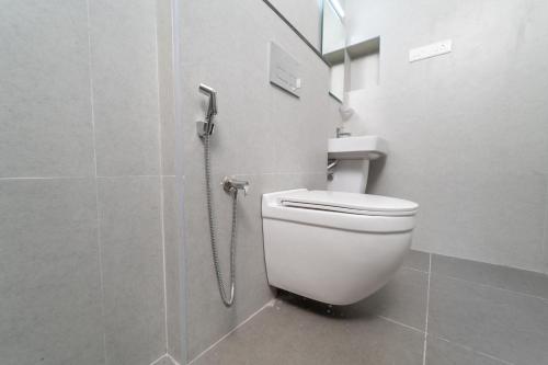 a white toilet in a bathroom with a shower at Mathi Residency in Chennai