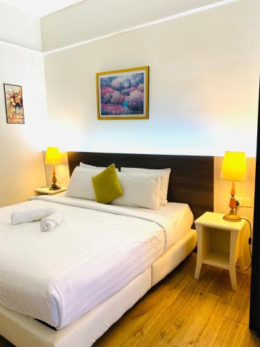 a bedroom with a large white bed with two lamps at My Service Suites Times Square KL in Kuala Lumpur